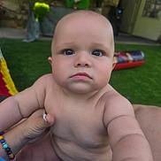 Nicolas is registered to the contest to win money with this photo: baby, child, infant, outdoor, grass, person, hand, bracelet, skin, expression, portrait, closeup, cute, young, nature, daylight, holding, face, looking, serious