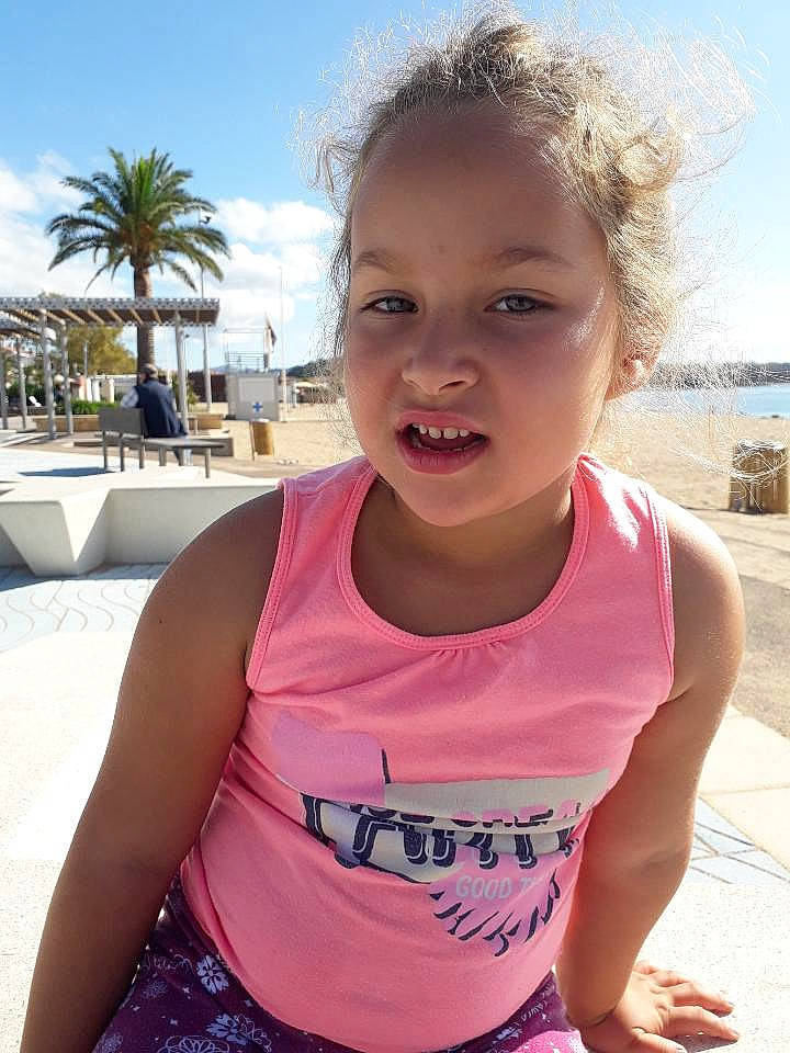 Myriam participe au concours pour gagner de l'argent avec cette photo : beach, child, face, facial_expression, forehead, fun, happy, head, leisure, mouth, neck, person, pink, play, shoulder, smile, summer, t_shirt, toddler, vacation
