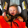 Malakai is registered to the contest to win money with this photo: baby, car_seat, child, smiling, orange_blanket, happy, infant, seatbelt, cute, indoor, person, toddler, clothing, head, face, hand, safety, wearing, closeup, cute_expression