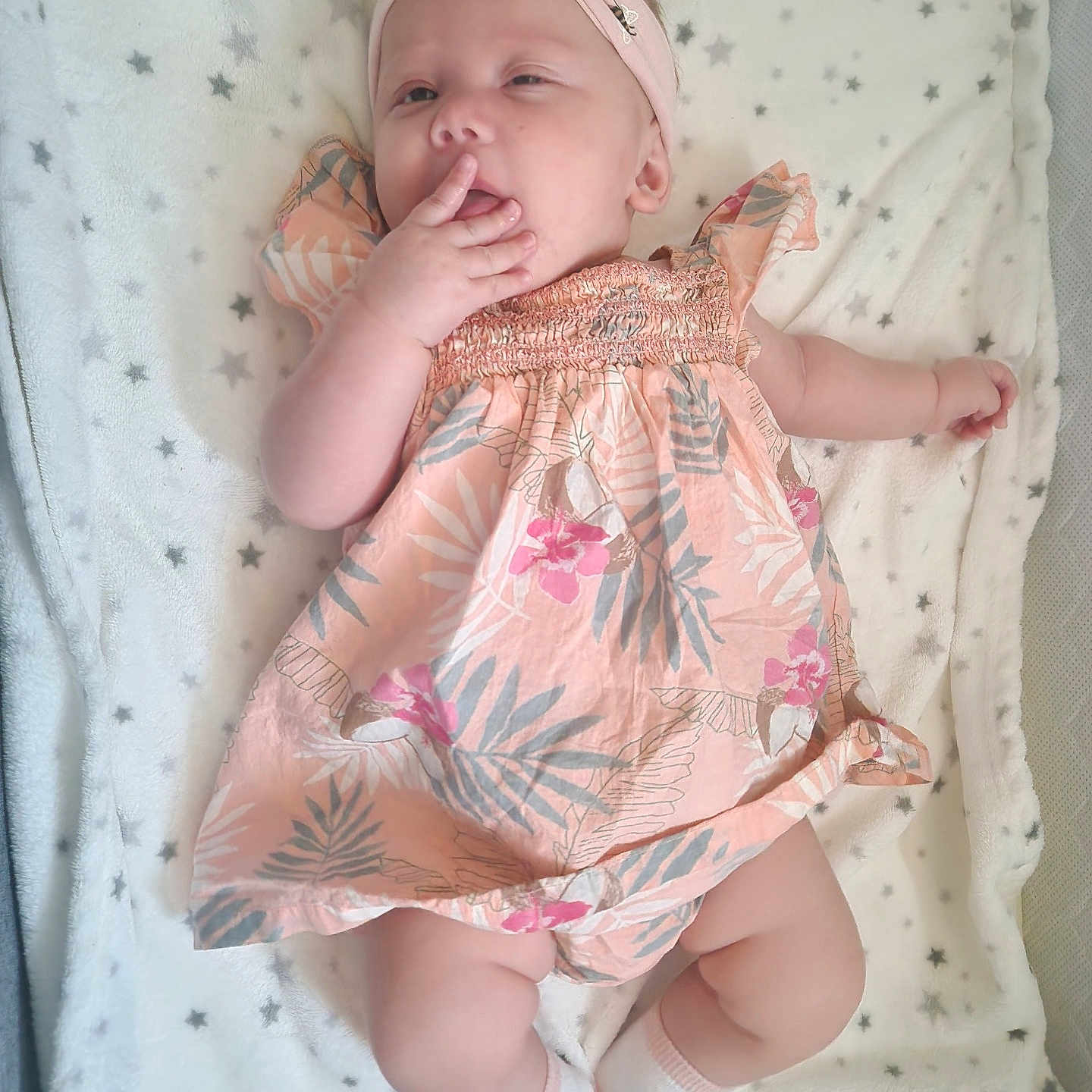 Lennox Arizona is registered to the contest to win money with this photo: baby, blanket, child, comfort, cute, dress, face, floral, hand, headband, infant, lying_down, pink, relaxed, skin, sleepy, socks, soft_texture, star_pattern, white