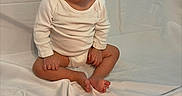 Mia is registered to the contest to win money with this photo: baby, child, birthday_cake, candle, yellow_headband, white_clothing, sitting, celebration, first_birthday, cake, sprinkles, indoor, portrait, cute, infant, smiling, face, feet, hands, white_background