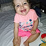 toddler, baby, child, smiling, happy, pink_clothing, shorts, tshirt, bed, indoor, toy, playful, cute, person, skin, foot, hand, face, hair, sleepwear