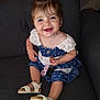 toddler, child, smiling, dress, blue_dress, white_sandals, keys, pacifier, sitting, couch, indoor, happy, young_child, hair, face, footwear, furniture, cute, person, portrait