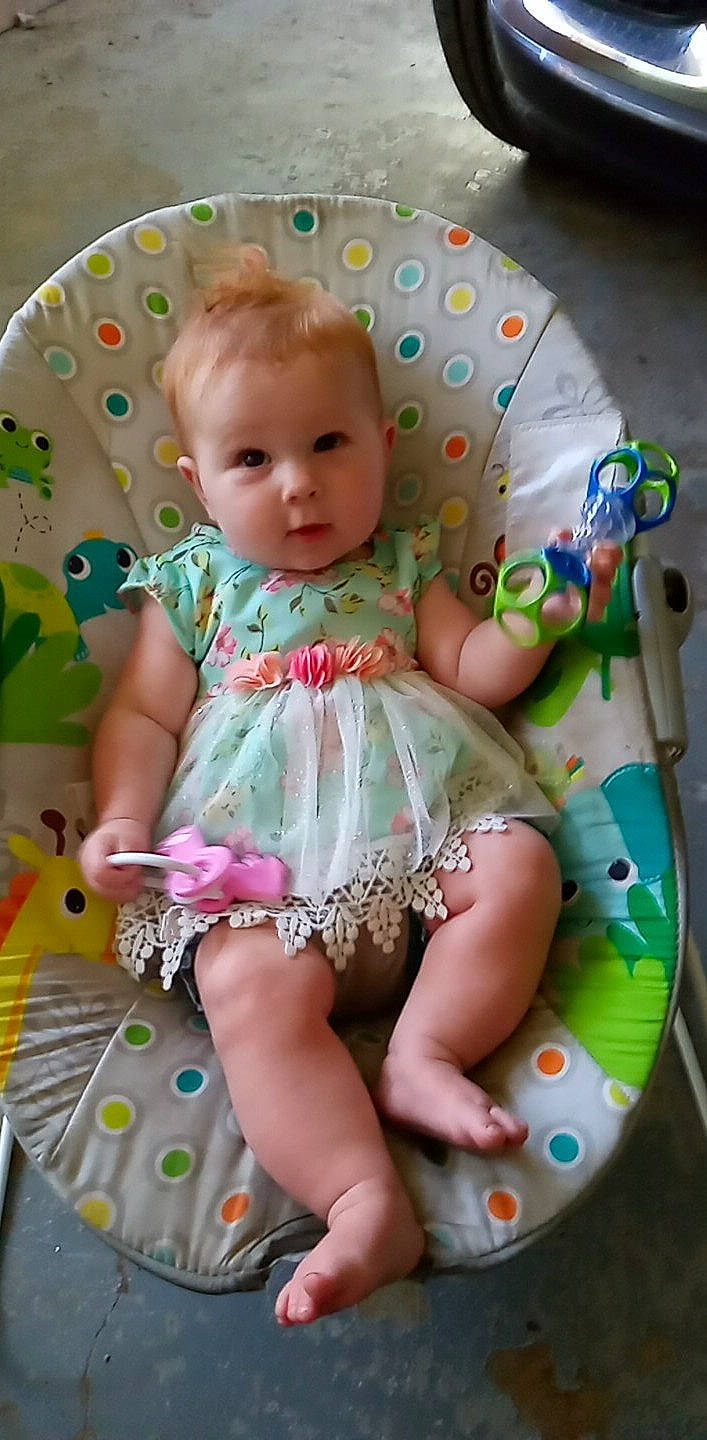 Raven is registered to the contest to win money with this photo: aqua, baby, baby_products, baby_toddler_clothing, cheek, dress, eye, face, hand, happy, iris, organ, pattern, person, pink, product, skin, sleeve, smile, textile