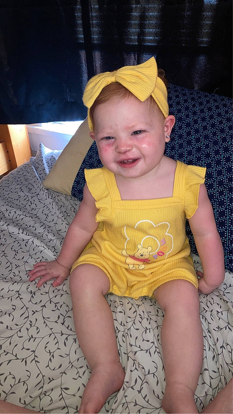 Carleigh is registered to the contest to win money with this photo: baby, baby_toddler_clothing, baseball_cap, blond, cap, cheek, child, facial_expression, fun, happy, head, human_leg, joy, lap, pattern, person, sitting, skin, sleeve, smile