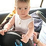 adult_hand, baby, car_interior, car_seat, child, clothing, hand, infant, person, safety, seat, seatbelt, serious_expression, short_hair, sitting, support, travel, vehicle, white_shirt, window