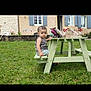 toddler, child, picnic_bench, grass, garden, house, window, flowers, outdoor, summer, green, bench, clothing, person, baby, nature, daylight, portrait, sitting, yard