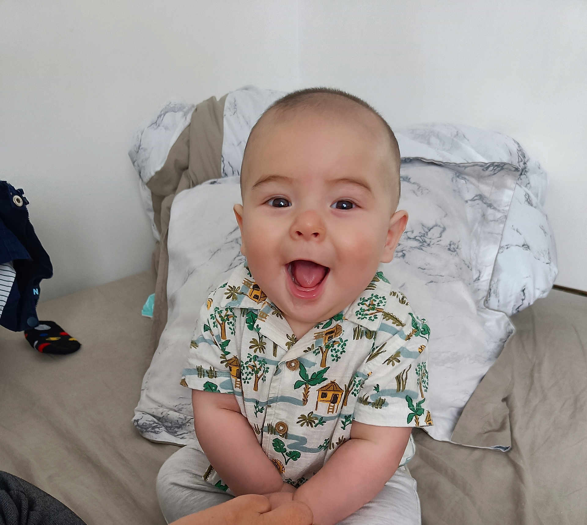 Dusser Dohan participe au concours pour gagner de l'argent avec cette photo : baby, smiling, happy, child, tropical_shirt, bed, pillow, indoor, person, cute, infant, sitting, clothing, home, joyful, portrait, face, hands, casual, young