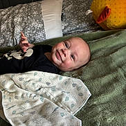 Josiah joined the competition — help win amazing prizes! baby, infant, smiling, blanket, plush_toy, bed, pillow, fabric, cozy, comfort, child, cute, indoor, person, resting, soft, young, happy, sleepwear, toddler