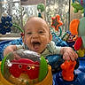 Esme joined the competition — help win amazing prizes! baby, child, infant, smiling, laughing, portrait, indoor, activity_center, playtime, toys, colorful, window, daylight, seated, hands, face, happy, nursery, toy_crab, baby_jumper