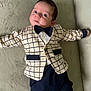 baby, bow_tie, child, clothing, cute, expression, eyes, face, fashion, feet, hands, indoors, infant, jacket, lying_down, person, portrait, socks, soft_surface, young