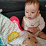 baby, child, clothing, couch, curious, cute, expression, fabric, face, giraffe, hands, illustration, indoor, infant, onesie, pattern, play_mat, seated, spot_pattern, toy