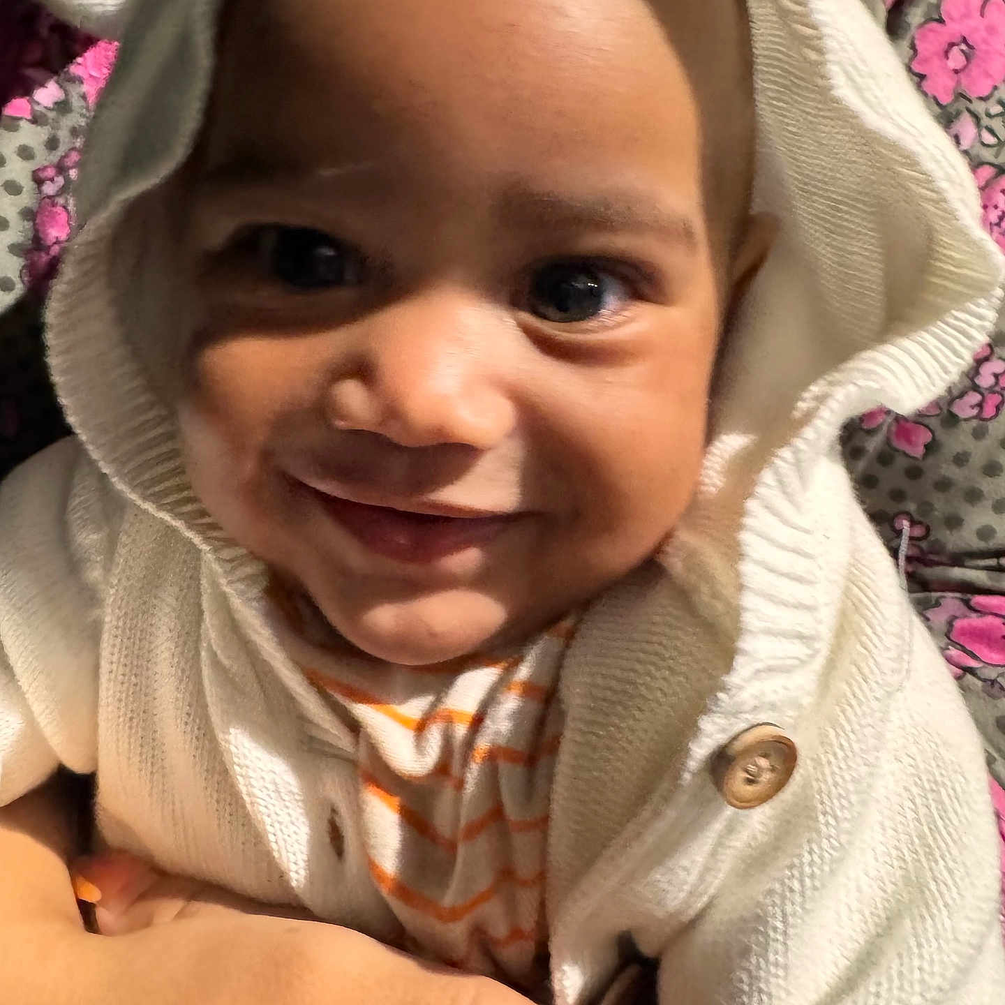 Kurrency is registered to the contest to win money with this photo: adult_hand, baby, button, child, closeup, colorful_background, cute, eyes, fabric, face, hand, hoodie, infant, knitwear, pattern, portrait, skin, smiling, striped_shirt, warm_clothing