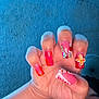 Kurrency joined the competition — help win amazing prizes! hand, nails, nail_art, pink, red, orange, flower_design, rhinestones, face, person, skin, fingernails, long_nails, decorated_nails, blue_wall, textured_wall, close_up, partial_face, portrait, indoor