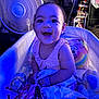 Bella is registered to the contest to win money with this photo: baby, blanket, child, clothing, crib, curtain, fan, furniture, happy, indoor, infant, person, pillow, portrait, room, sitting, smiling, stuffed_animal, toy, water_bottle