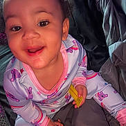 Bella joined the competition — help win amazing prizes! toddler, child, smiling, pajamas, koala, rainbow, hand, face, indoors, bedding, blanket, comfort, happy, young_child, sitting, clothing, person, cute, playful, cozy