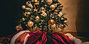 Leya a rejoint le concours — aidez-le/la à gagner de superbes lots ! baby, carpet, christmas_tree, cozy, decorations, fairy_lights, festive, floor, holiday, indoor, newborn, night, ornaments, peaceful, plush_trim, portrait, red_clothing, santa_costume, sleeping, warm_lighting