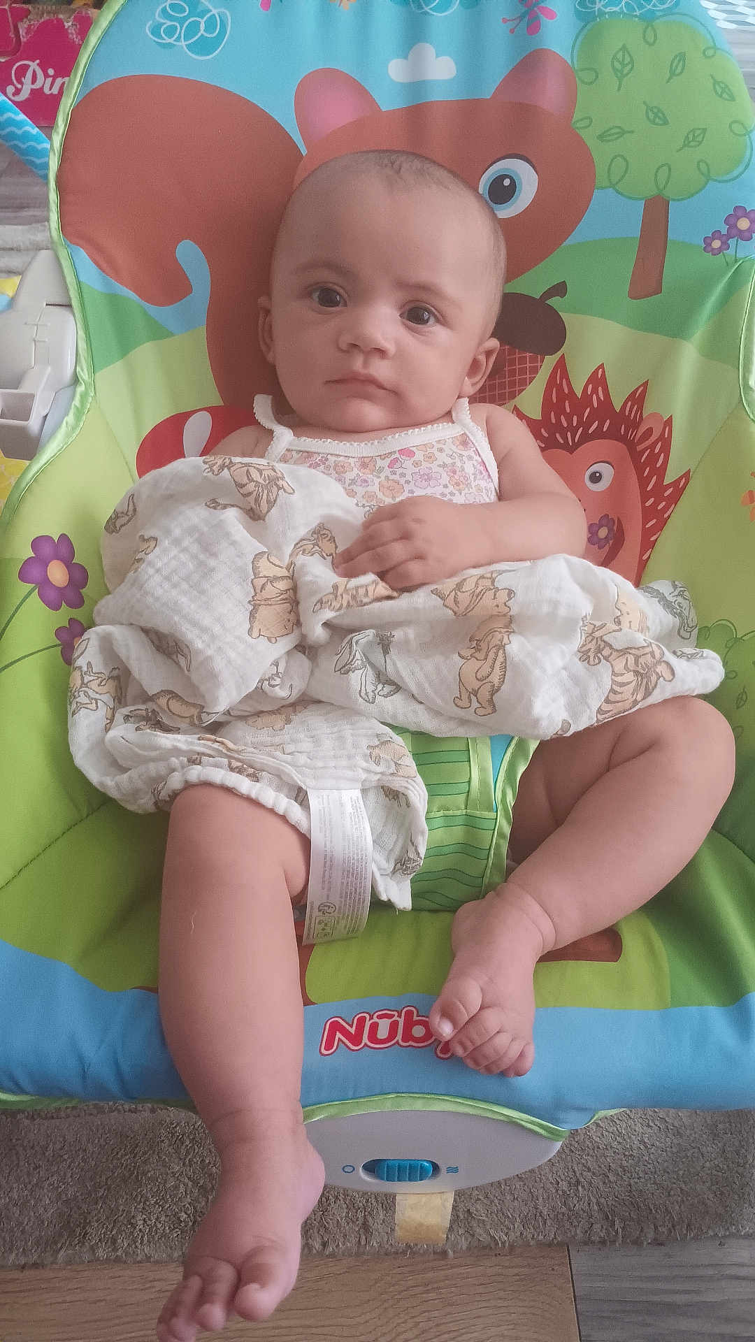Evelyn joined the competition — help win amazing prizes! baby, child, blanket, baby_chair, colorful, indoor, carpet, wooden_floor, animal_print, cute, infant, person, sitting, face, expression, hand, foot, clothing, toy_design, fabric
