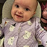baby, child, infant, smiling, portrait, indoors, seated, lavender_clothing, quilted_outfit, ghost_pattern, costume, cozy, chair, cushion, toy, face, eyes, happy, close_up, photography
