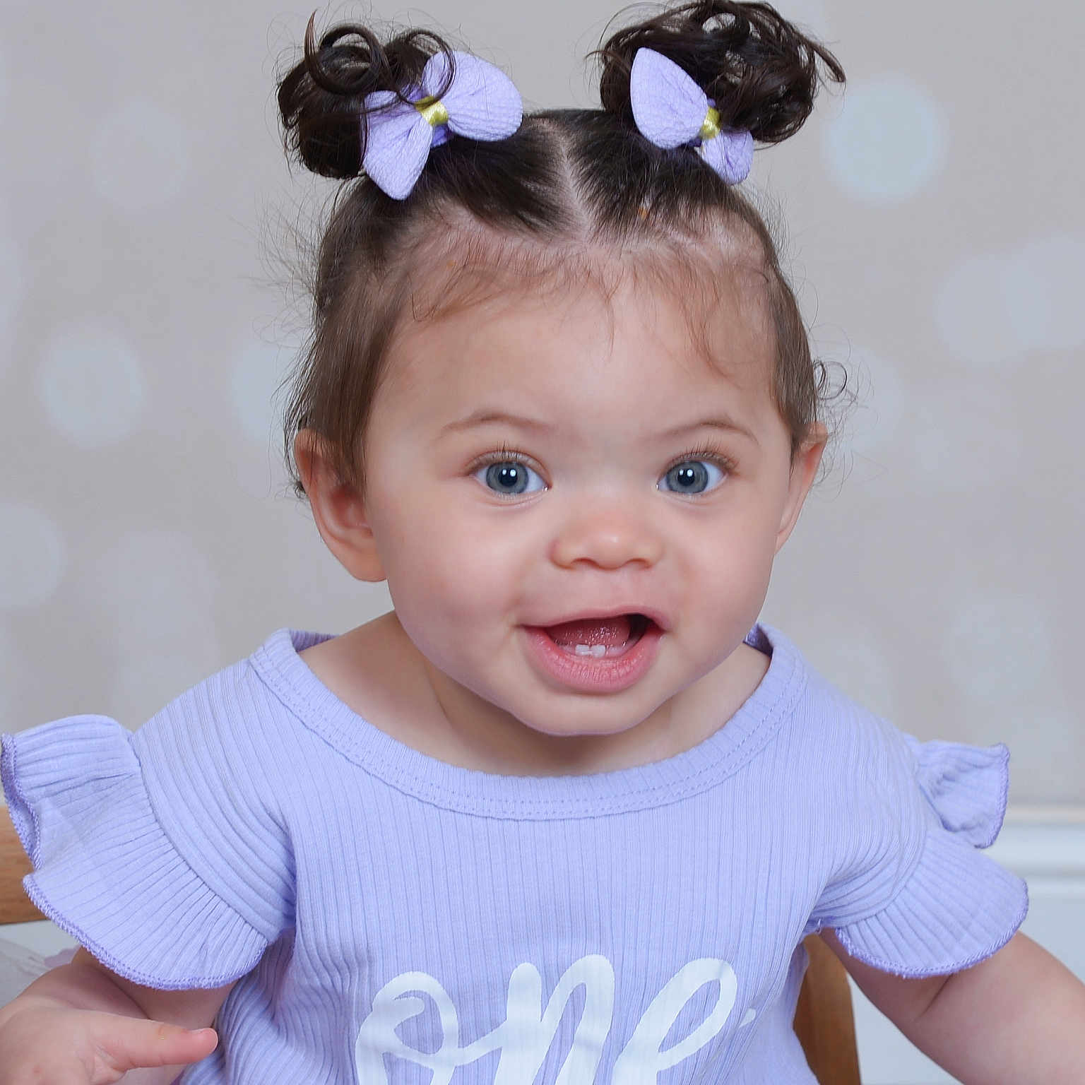 Ziora joined the competition — help win amazing prizes! baby, blue_eyes, bokeh_background, child, closeup, cute, face, hair_buns, happy, indoor, infant, lavender_shirt, one_text, person, portrait, purple_bows, sitting, smiling, toddler, wooden_chair