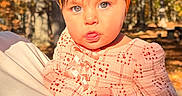 Zoe is registered to the contest to win money with this photo: baby, child, portrait, outdoor, autumn, fall, forest, trees, orange_headband, bow, pink_outfit, floral_clothing, infant, wide_eyes, looking_at_camera, cuddling, daylight, nature, family, close_up