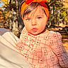 baby, child, portrait, outdoor, autumn, fall, forest, trees, orange_headband, bow, pink_outfit, floral_clothing, infant, wide_eyes, looking_at_camera, cuddling, daylight, nature, family, close_up