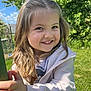 child, smiling, outdoor, greenery, grass, tree, blue_sky, clouds, happy, young_girl, long_hair, jacket, hand, sunlight, garden, nature, casual_clothing, daytime, portrait, playful