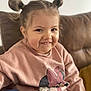 child, girl, smiling, hair_buns, minnie_mouse, sweatshirt, pink_clothing, couch, indoor, portrait, cute, happy, person, young_child, casual, seated, cozy, home, fashion, face