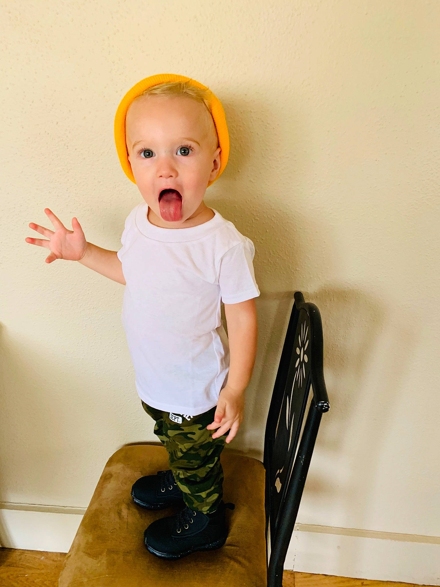 Azriel is registered to the contest to win money with this photo: baby, baby_toddler_clothing, child, child_model, footwear, headgear, person, photography, product, shoe, sitting, sleeve, standing, surprise, t_shirt, toddler, yellow