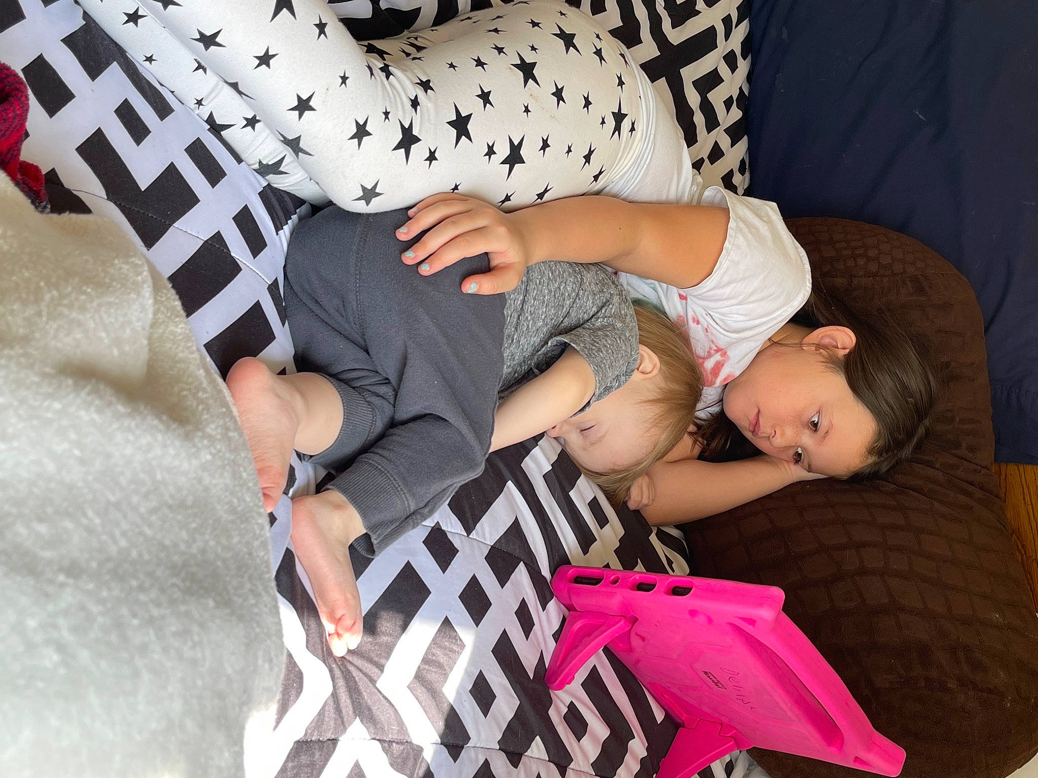 Delilah is registered to the contest to win money with this photo: child, comfort, elbow, event, foot, human_leg, joint, knee, lap, leisure, nail, pattern, person, sitting, sleeve, sock, sportswear, t_shirt, textile, thigh