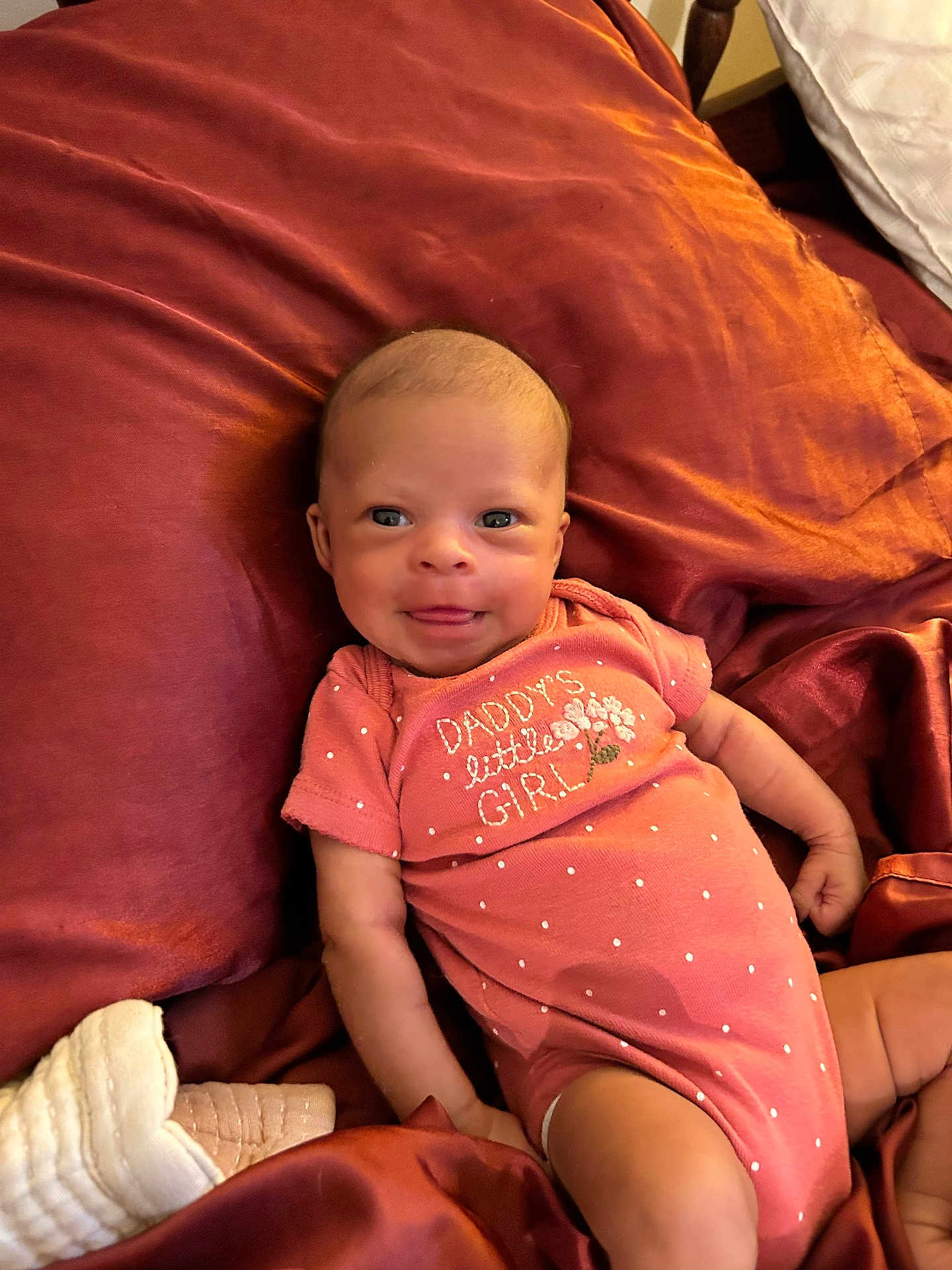 Xylie joined the competition — help win amazing prizes! baby, infant, smiling, onesie, pink_clothing, blanket, fabric, cute, child, portrait, face, lying_down, small_hands, happy, young_child, indoors, cozy, soft_lighting, newborn, resting