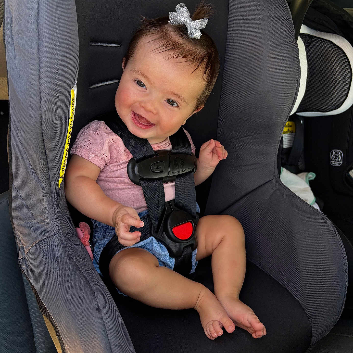 Elleauna joined the competition — help win amazing prizes! baby, child, car_seat, smiling, happy, infant, seatbelt, bow, pink_clothing, denim_shorts, car_interior, safety_harness, cute, portrait, sitting, young_child, face, person, happy_expression, car