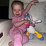 Fiona is registered to the contest to win money with this photo: baby, child, comfortable, cute, daisy_duck, foot, happy, heart_pattern, indoor, laughing, person, pink_pajamas, plush_toy, portrait, raised_arm, relaxed, smiling, toddler, toy, white_leather_chair