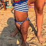 baby, back, bikini, bodypart, clothing, face, finger, footwear, hand, happy, head, outdoors, person, photography, portrait, shorts, smile, soil, summer, swimwear