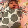 baby, newborn, blanket, hat, bow, sleeping, infant, wrapped, cute, floral, pillow, pattern, polka_dot, cozy, resting, child, soft, indoors, portrait, peaceful
