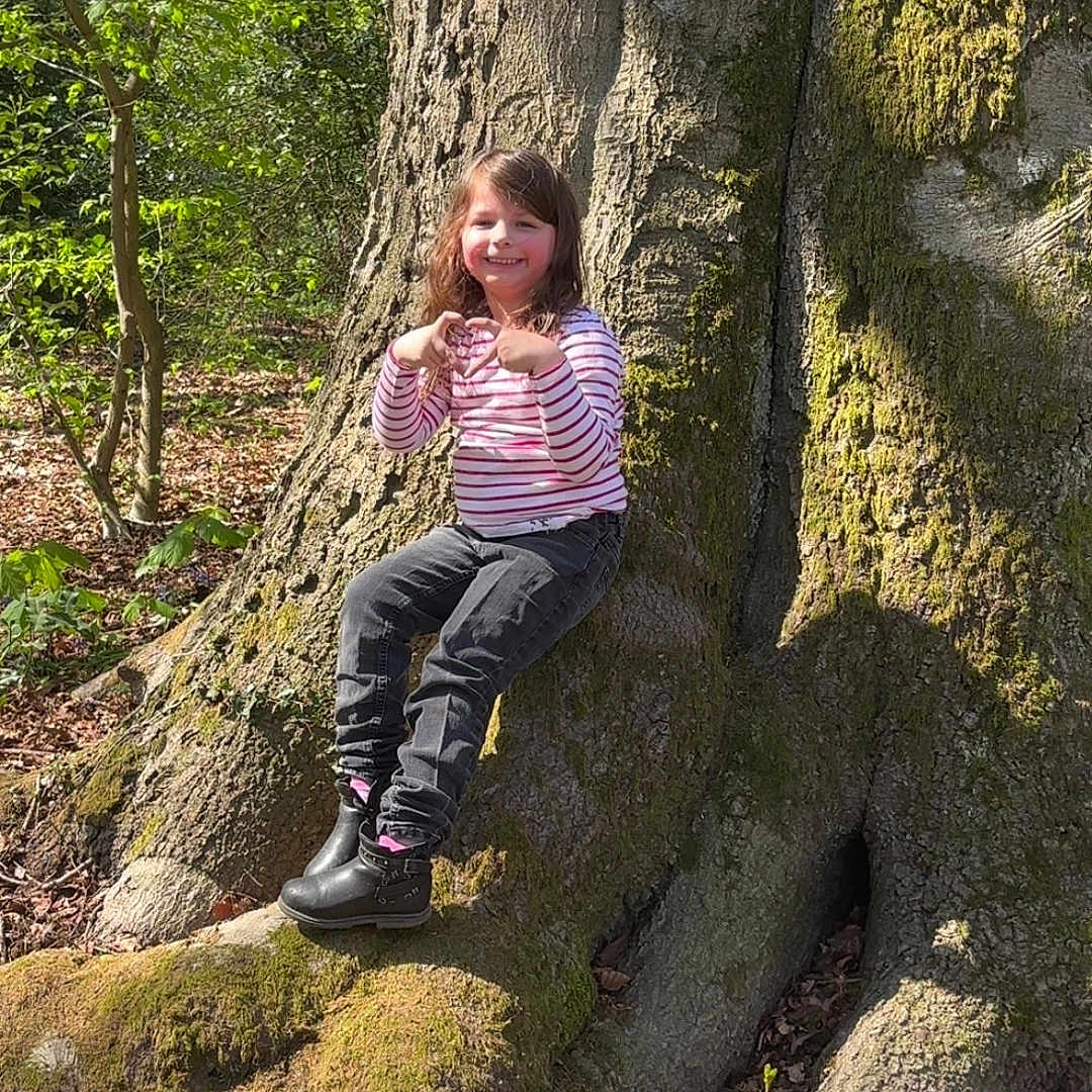 Alyah Hasibe Bal Delatte a rejoint le concours — aidez-le/la à gagner de superbes lots ! child, clothing, face, female, girl, grove, head, land, nature, outdoors, pants, person, photography, plant, portrait, rock, sitting, tree, vegetation, woodland