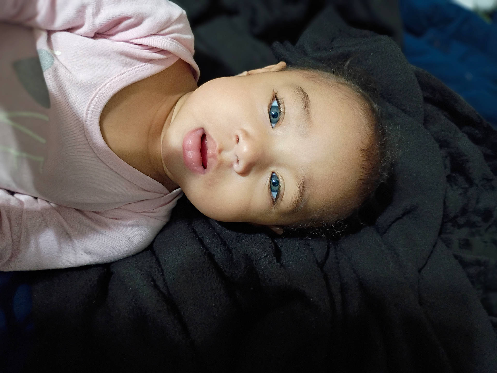 Ana is registered to the contest to win money with this photo: adorable, baby, blanket, blue_eyes, child, closeup, cute, expression, face, head, indoor, infant, lying_down, person, pink_clothing, portrait, skin, sleepwear, soft_texture, young_child