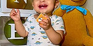 Mikah is registered to the contest to win money with this photo: toddler, child, smiling, dinosaur_print, shirt, blue_jeans, socks, toy_block, balloons, green_balloons, birthday, celebration, yellow_teddy_bear, stuffed_animal, ribbon, floor, indoor, happy, face, person