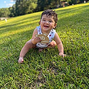 Judah is registered to the contest to win money with this photo: baby, child, grass, outdoor, smiling, happy, park, greenery, infant, cute, sunlight, nature, sitting, ten_months, person, portrait, young_child, summer, daylight, casual_clothing