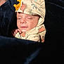 baby, child, infant, hood, dinosaur, blanket, sleepy, cute, soft_lighting, clothing, snuggled, plush, face, portrait, indoors, cozy, young, resting, person, warm