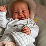 Evelyn joined the competition — help win amazing prizes! baby, smiling, tongue_out, white_clothing, blanket, plush_toy, cushion, infant, cute, happy, indoors, child, portrait, soft_texture, head_support, hand, face, cozy, sleepwear, comfort