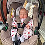 baby, infant, car_seat, stroller, sleeping, plush_toys, onesie, outdoor, flowers, blanket, seatbelt, baby_clothing, head, face, hand, footwear, toy, wheel, fabric, nature