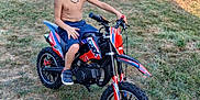 Iago a rejoint le concours — aidez-le/la à gagner de superbes lots ! child, boy, dirt_bike, motorbike, outdoor, grass, summer, necklace, shorts, shoes, fence, sunlight, backyard, toy_vehicle, play, leisure, casual, nature, daytime, adventure