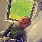 Iago participe au concours pour gagner de l'argent avec cette photo : child, boy, hoodie, seat, window, vehicle, travel, playing, face, expression, indoor, casual_clothing, young, portrait, seat_cover, bag, seatbelt, motion_blur, green_background, funny_face