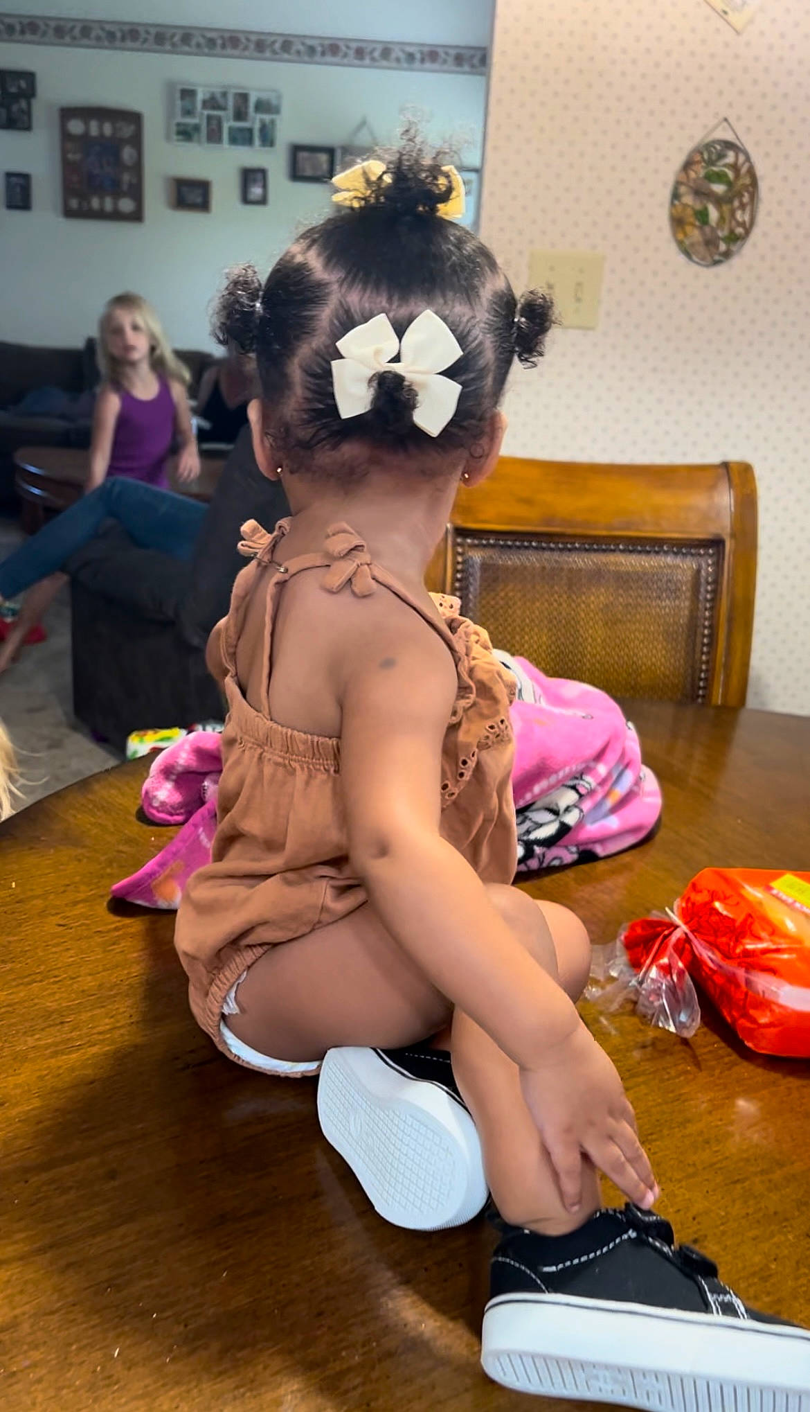 Niome is registered to the contest to win money with this photo: abdomen, blurred, child, costume, fawn, fictional_character, flooring, fun, fur, hat, human_leg, person, personal_protective_equipment, picture_frame, pink, sandal, shoe, sitting, stuffed_toy, thigh