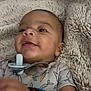 Jaidyn is registered to the contest to win money with this photo: baby, blanket, carrot_pattern, child, clothing, comfort, cute, expression, face, hand, happy, head, indoors, infant, lying_down, onesie, pacifier, skin, smiling, soft_texture
