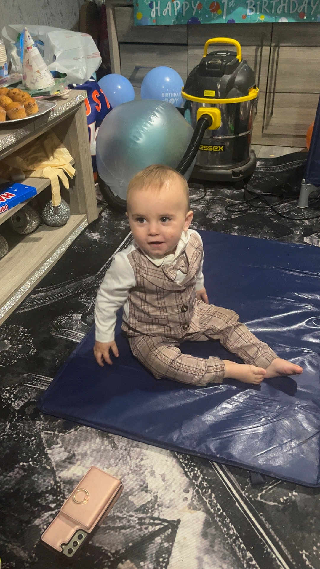 Jaxson joined the competition — help win amazing prizes! toddler, child, birthday, party, balloons, vacuum_cleaner, smartphone, plaid_suit, bow_tie, mat, floor, indoor, decorations, cupcakes, table, furniture, blue, curious, person, celebration