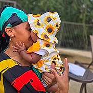 Nanyamka joined the competition — help win amazing prizes! baby, adult, hug, sunflower, hat, outdoor, nature, bracelet, earring, clothing, person, affection, love, family, portrait, smile, hat_pattern, colorful, closeup, holding