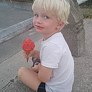 Raphaël participe au concours pour gagner de l'argent avec cette photo : child, blonde_hair, ice_cream, cone, sidewalk, concrete, sitting, smiling, white_shirt, shorts, outdoor, railing, stone_post, summer, casual, happy, food, snack, person, playful