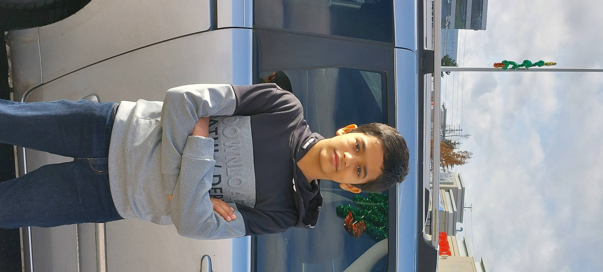 Devarsh is registered to the contest to win money with this photo: building, city, denim, elbow, facade, gesture, human_leg, joy, pedestrian, person, sitting, sleeve, smile, street, street_fashion, travel, vehicle_door, waist